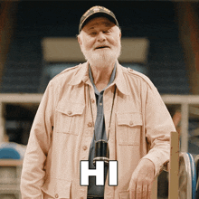 an elderly man wearing a uss coral sea cap says hi