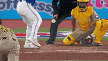 a baseball game is underway and the catcher is wearing a yellow uniform