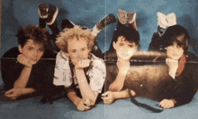 a group of young men laying on their stomachs with one wearing a shirt that says ' i love ' on it