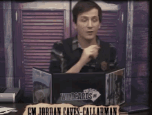 a man sitting in front of a table with a sign that says wildcards on it