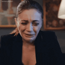 a woman in a black jacket is crying with the name keyserpayasli written on the bottom