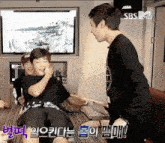 a group of young men are playing a game in front of a tv screen that says sbs mv