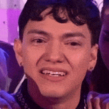 a young man with braces on his teeth is smiling for the camera .
