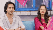 a man and a woman are sitting on a couch .