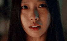 a close up of a woman 's face with a tear coming out of her nose .