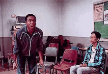 a man is standing in front of a group of people sitting in chairs in a room .