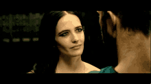 a woman looks at a man in a dark room