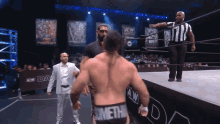 a wrestler with the word meth on his shorts is standing on the ring