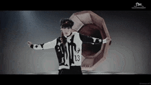 a man in a black and white jacket with the number 13 on the front