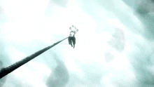 a person is hanging from a rope in the sky with a clock on it .