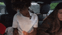 a man in a white shirt is sitting in the back seat of a car next to a woman