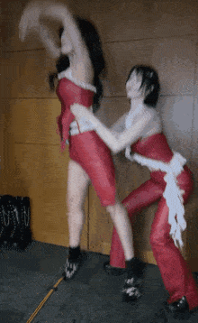 a woman in a red dress is standing next to another woman