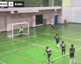 a soccer game is being played in a gym with 6:40 on the scoreboard