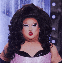 a drag queen is wearing a pink corset and a wig