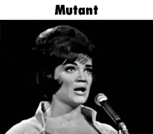 a woman singing into a microphone with the word mutant on the bottom