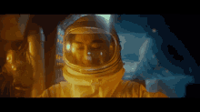 a woman in an astronaut 's helmet looks down at something