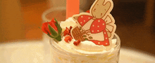 a dessert with whipped cream strawberries and a bunny on top of it
