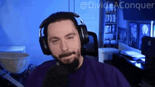 a man wearing headphones and a purple shirt with the words divide aconquer written above him