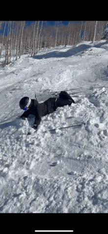 a person laying in the snow wearing a helmet