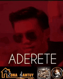 a man wearing sunglasses is standing in front of a sign that says adhere