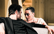 a man and a woman are looking at each other and the woman is wearing a ring on her finger