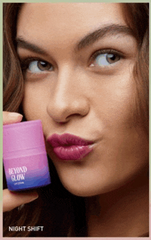 a woman is holding a bottle of beyond glow in her hand