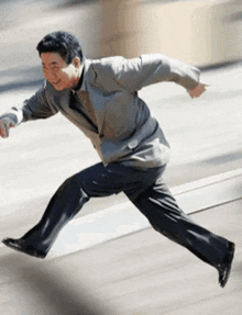 a man in a suit and tie is running on a street