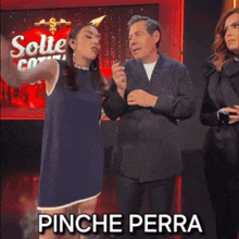a woman in a blue dress is dancing with a man in a suit in front of a sign that says solte coti