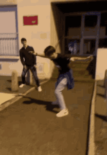 a blurry picture of a man dancing on the sidewalk