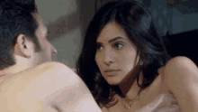 a man and a woman are looking at each other in a bedroom