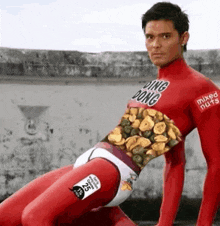 a man in a red bodysuit with mixed nuts on his shirt