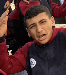 a boy wearing a red and black jacket with the letter a on the front