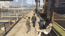 a man in a suit is walking down a sidewalk next to a woman sitting on a bench in a video game
