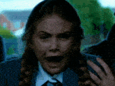 a girl in a school uniform is making a funny face