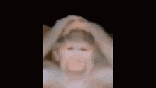 a blurry picture of a person holding their head in the dark .