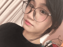 a girl wearing glasses and a black shirt