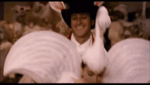 a man in a cowboy hat is holding a white rabbit .