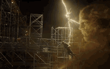 a lightning bolt strikes a scaffolding structure while a man looks on