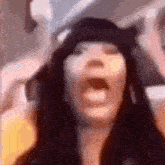 a close up of a woman with her mouth open wearing a hat .