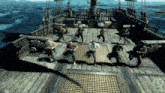 a group of men are dancing on the deck of a ship in the ocean