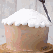 a cake is being frosted with white frosting by a knife