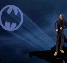 a man standing in front of a batman logo