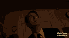 a man in a suit and tie is looking up at the sky in a room .