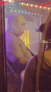 a man sitting in front of a sign that says ' man '