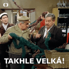 a group of men are standing in front of a sign that says takhle velka!