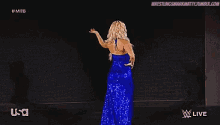 a woman in a blue dress is dancing on a stage