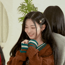 a girl wearing a brown sweater with a star in her hair
