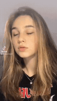 a girl with long hair is wearing a black shirt with the word atlanta on it .