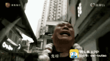 a man is crying in front of a building with the app wei-toutiao in the corner