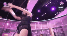 a woman in a black dress is dancing in front of a purple ceiling and a sign that says shut down